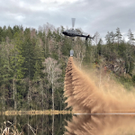 Helikoptern genomför kalkning på en sjö.