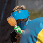 Bilden visar en ungdom som har skyddsmask och spelar paintball.