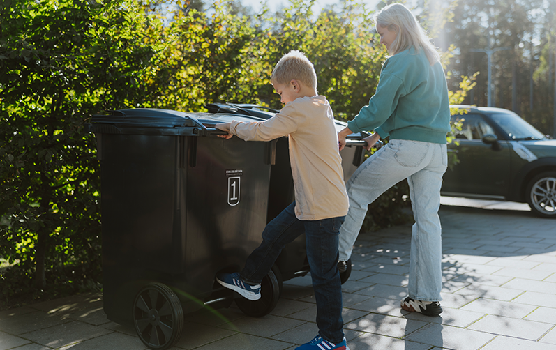 Mor och son hanterar Kretslopp Sydosts nya fyrfackskärl.