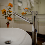 Bilden visar en vattenkran som rinner i ett badrum.